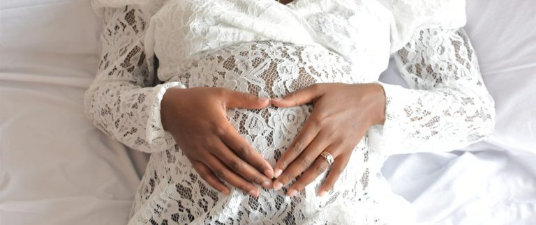 Schwangere Frau in Umstandsbrautkleid